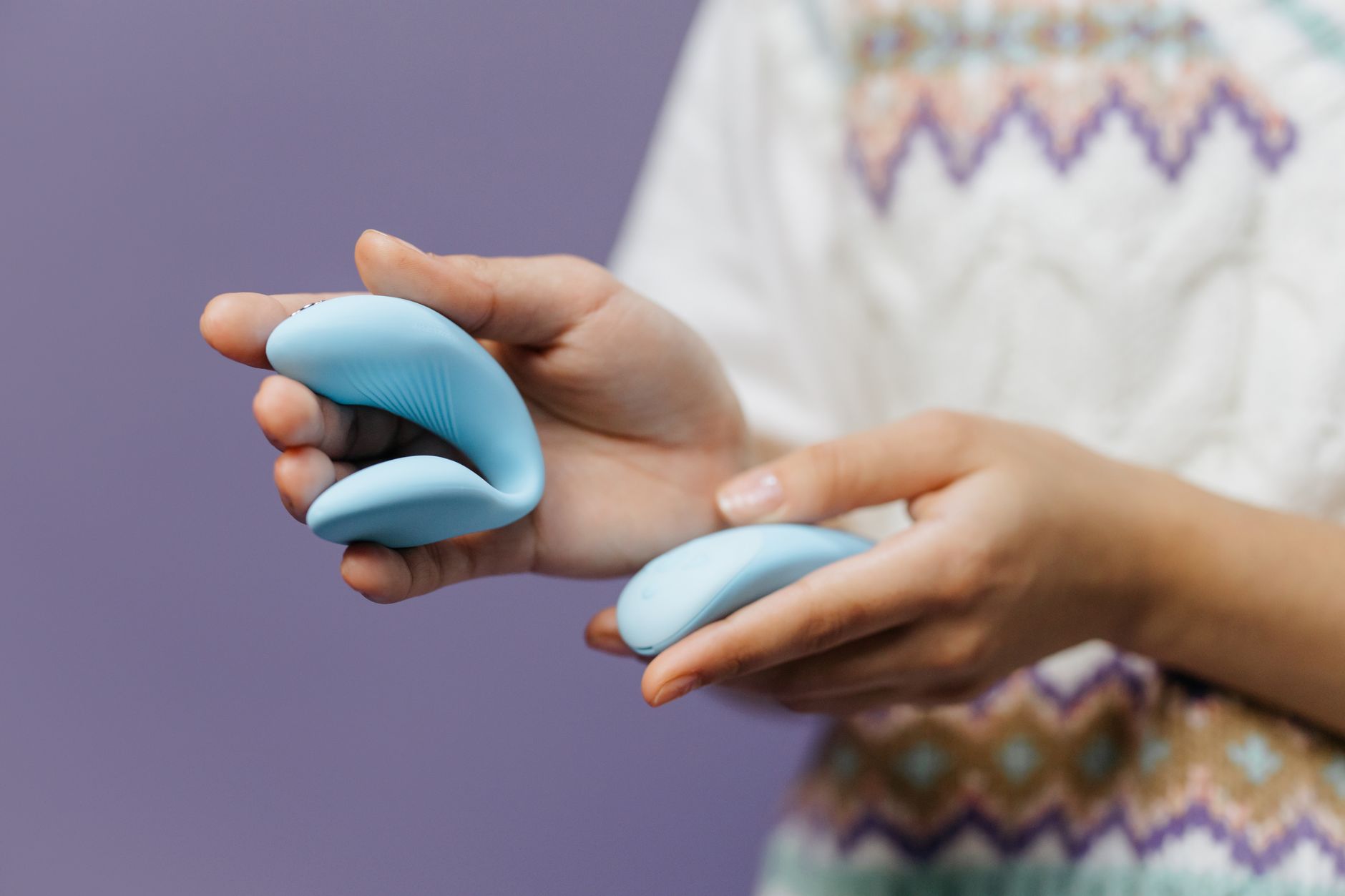 Pareja joven sosteniendo juntos un vibrador azul, simbolizando la intimidad moderna en una relación nueva