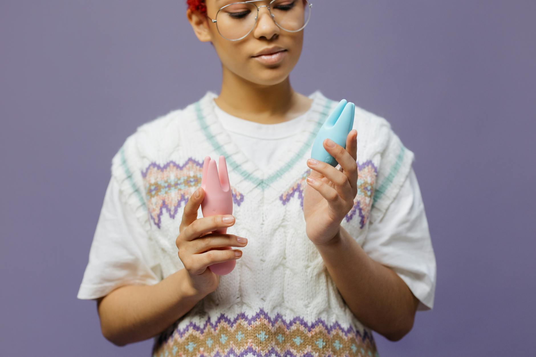 Woman holding silicone vibrators, contemplating new ways to connect with a partner
