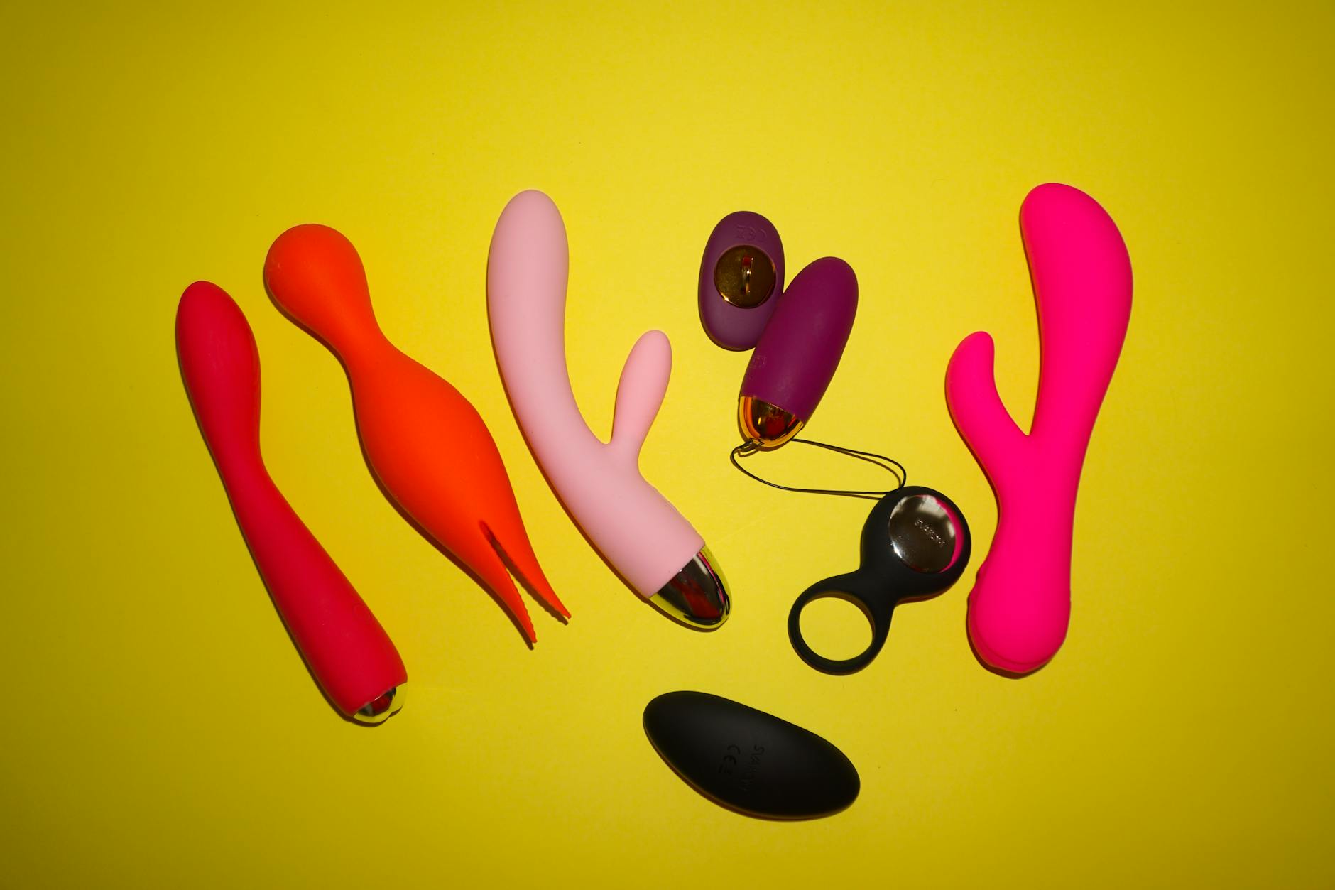 Hand holding a vibrator against a purple backdrop, showcasing clitoral pleasure tools